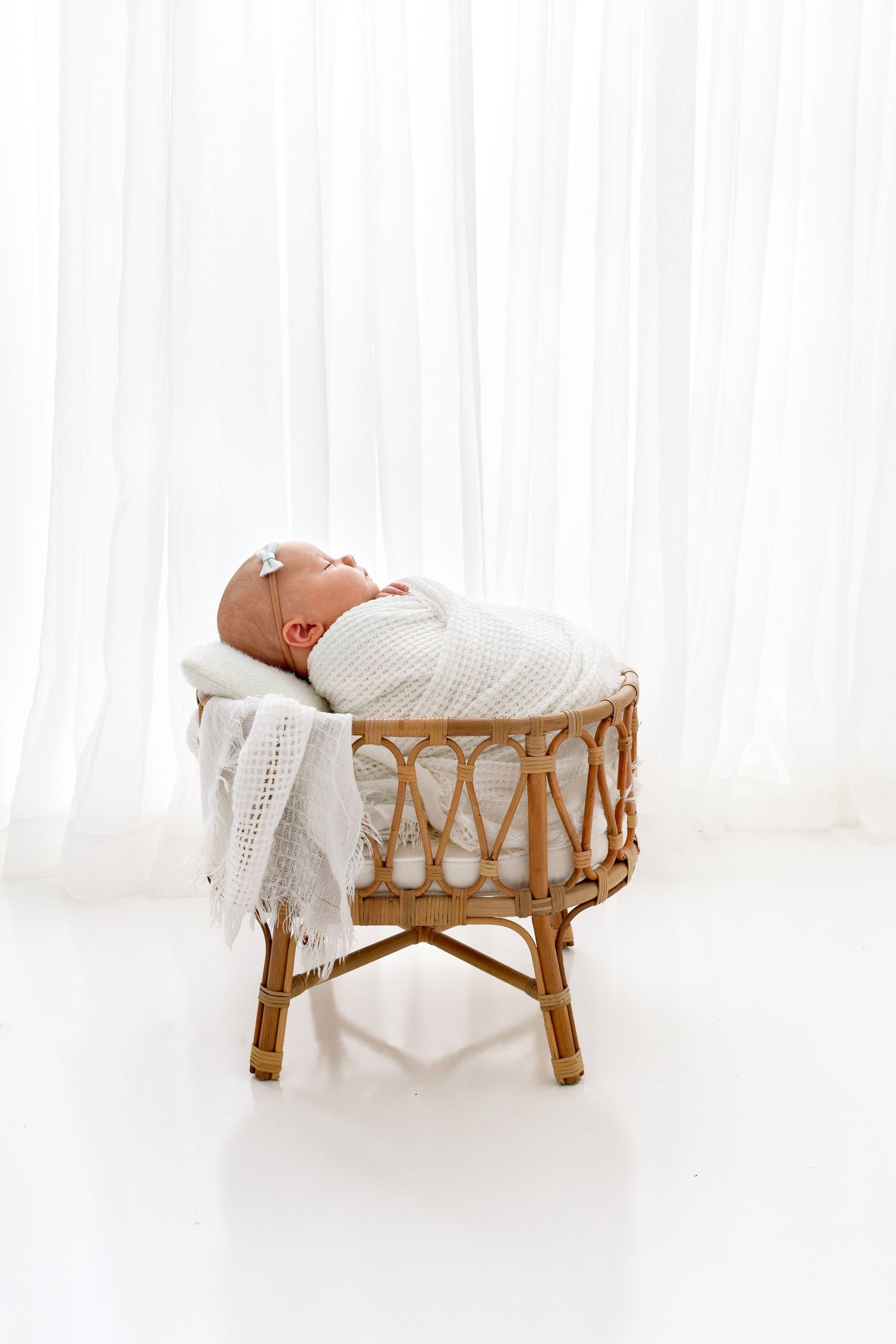 Baby all wrapped up and sleeping peacefully in a tiny crib during newborn photo session in Victoria BC Canada
