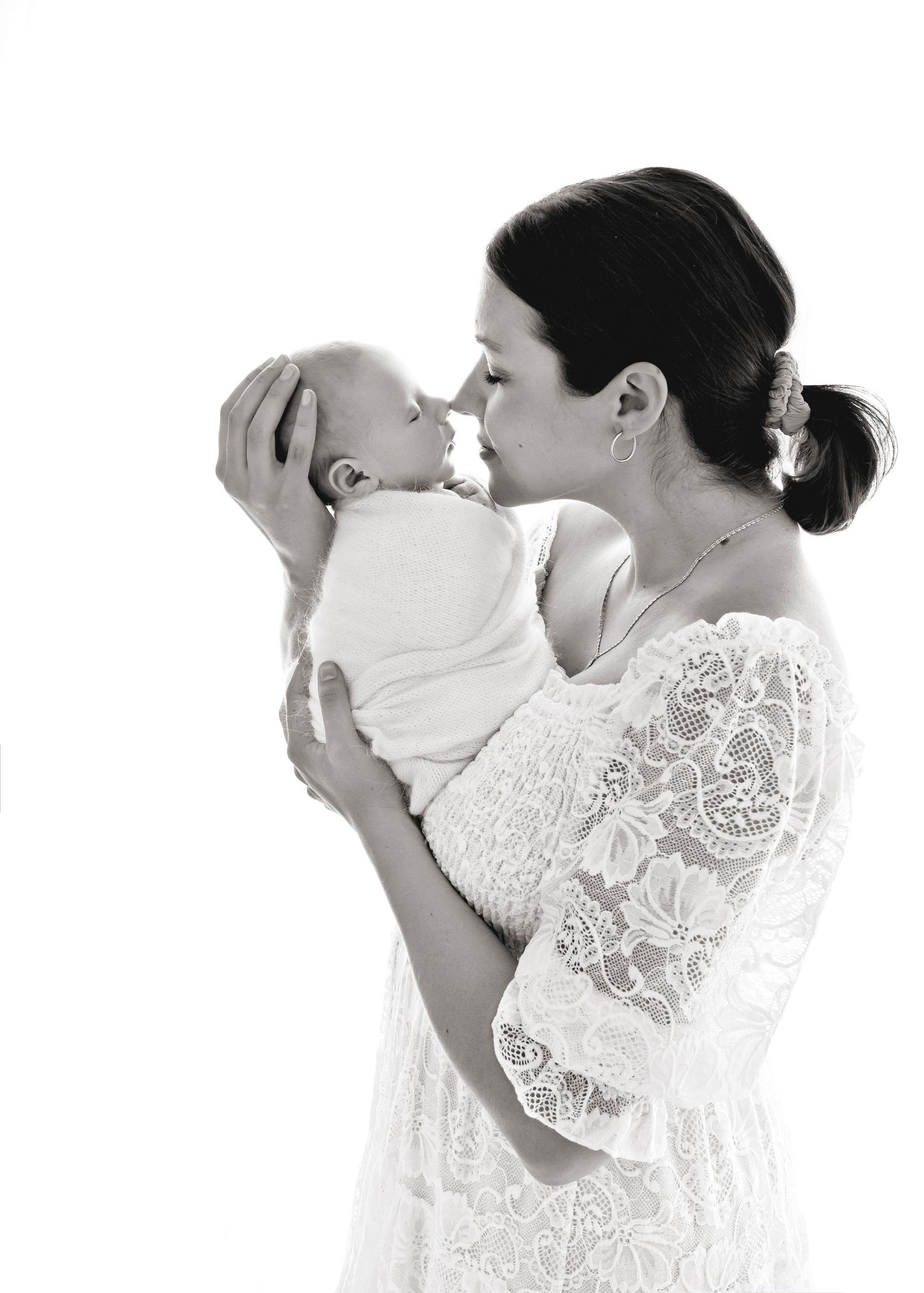 Mama touching noses with her newborn baby