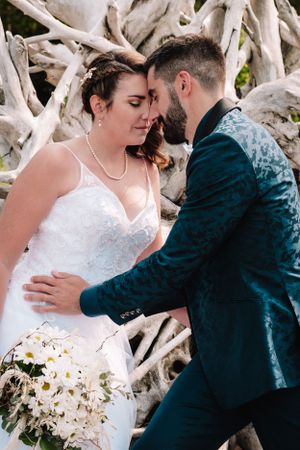 Intimate wedding moment against whitewashed driftwood backdrop.