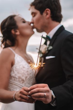 Wedding couple sharing a romantic moment while holding a sparkler during their special celebration.