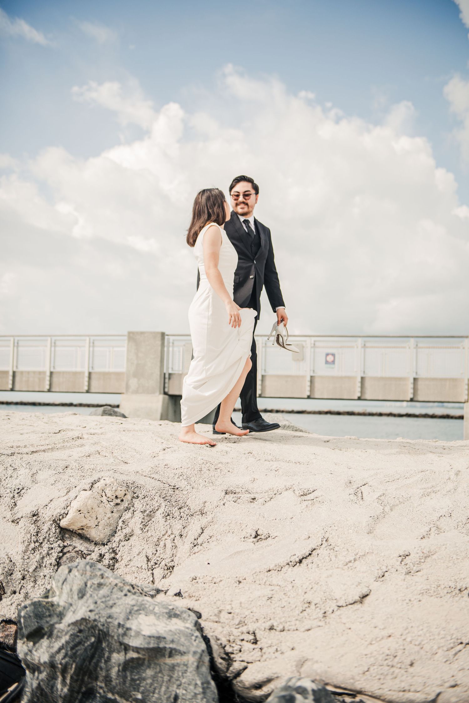 Wedding couple sharing romantic moment on sandy beach overlook.