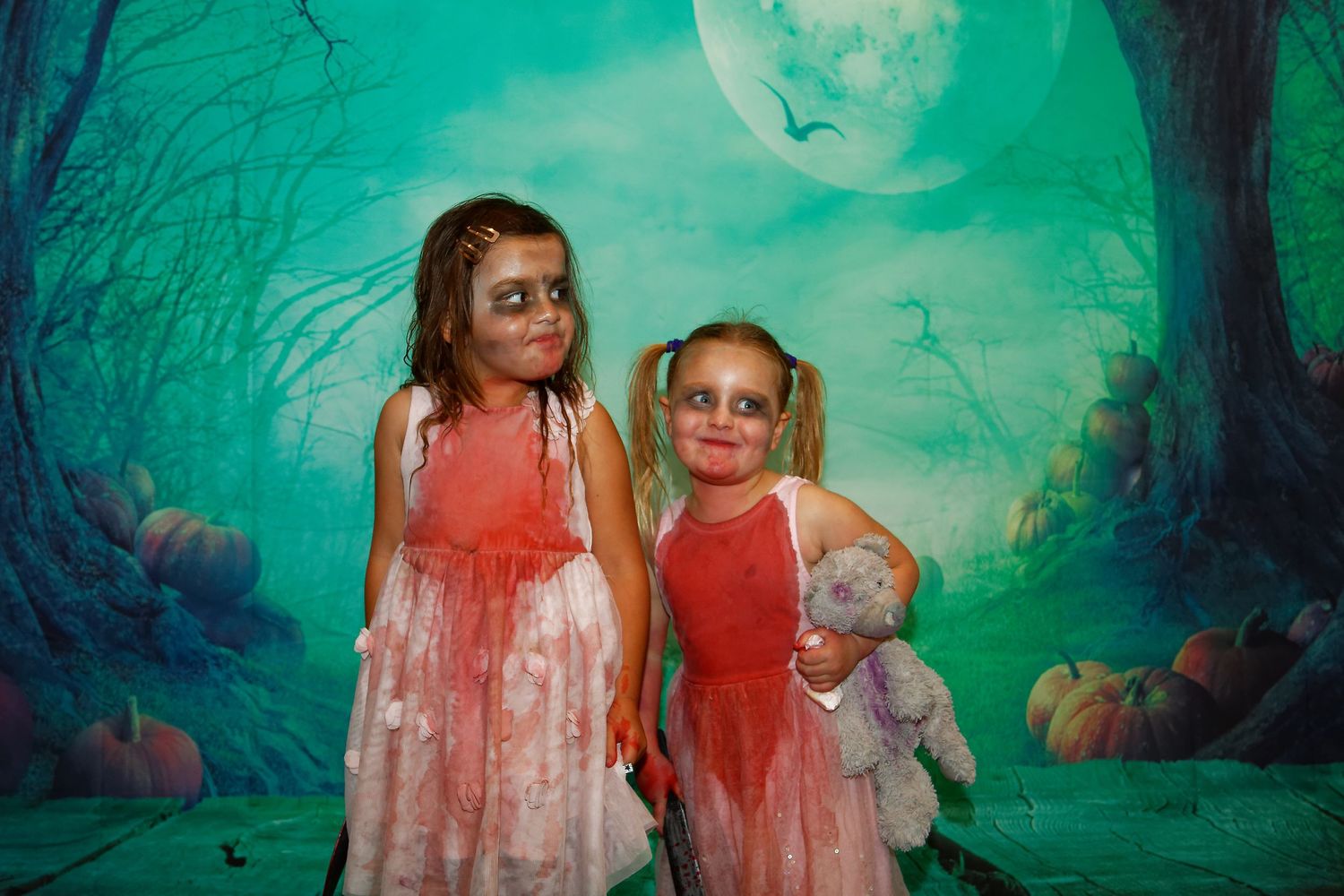 A spooky Halloween-themed photo shoot with green moonlit forest backdrop.