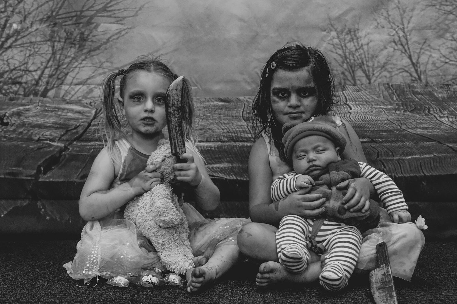 Black and white portrait of children with spooky makeup holding stuffed toys.