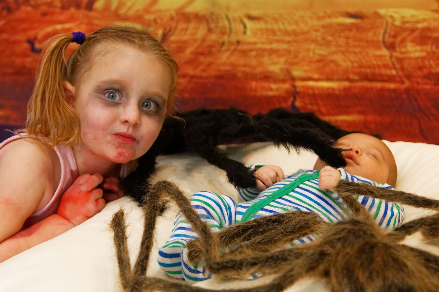 Child resting with striped puppet props on white bean bag.