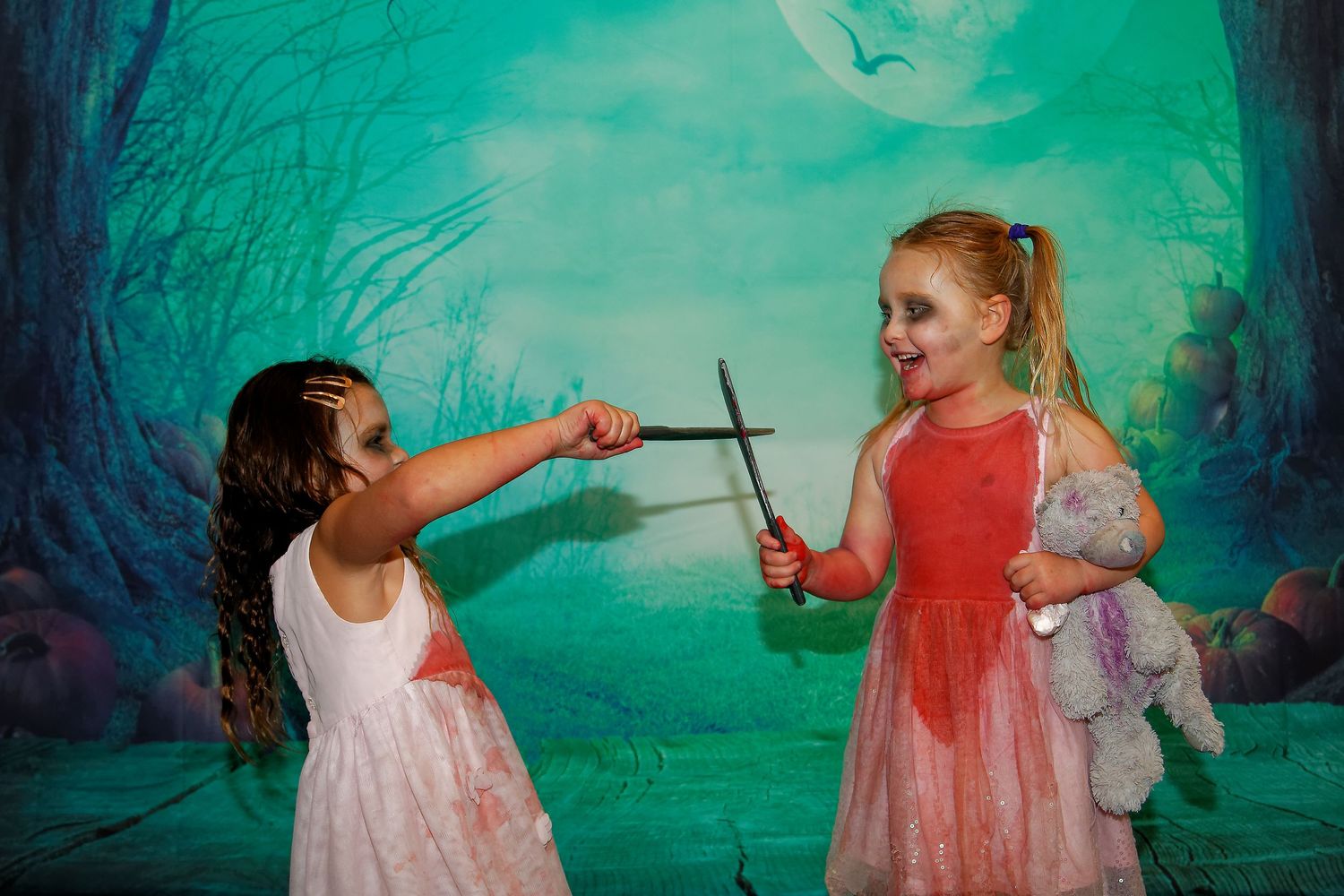 Theatrical scene with crossed swords against an eerie forest backdrop.