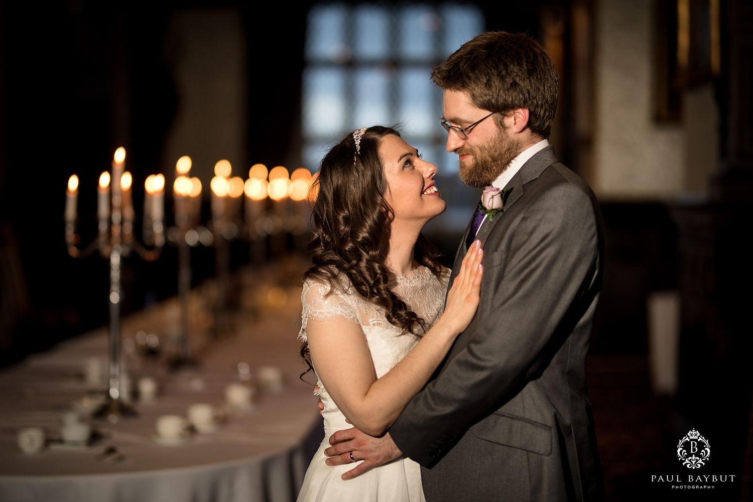 Romantic couple embrace by candlelight during intimate wedding moment.