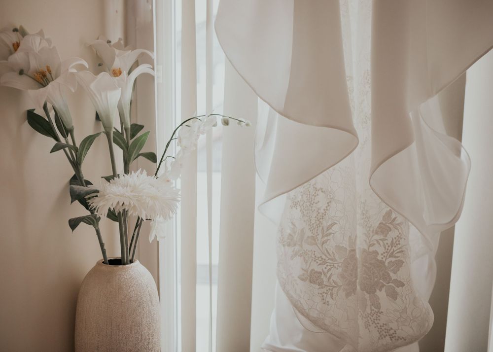 wedding dress hanging in window photography