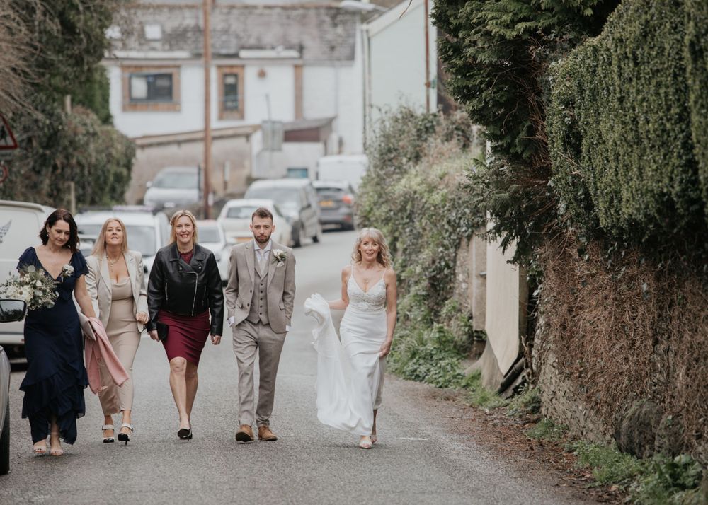 bride and bridesmaids walking to village church photography