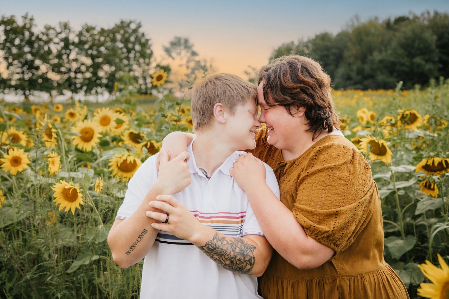 Intimate moment captured in a blooming sunflower field during golden hour.