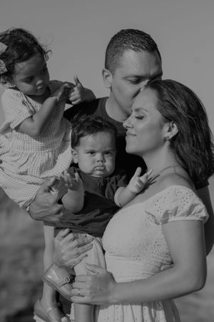 An intimate black and white family portrait showing tender moments together.