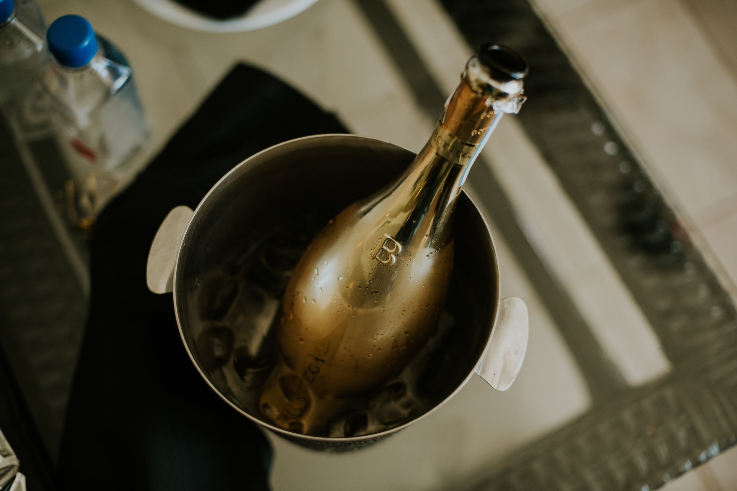 Gold champagne bottle chilling in an ice bucket.