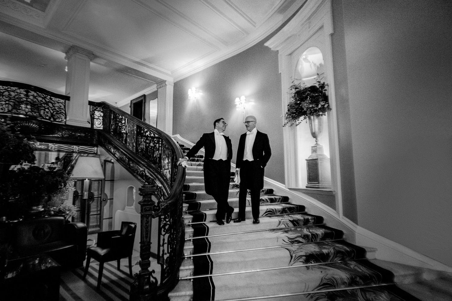 Grooms posing on elegant stairs at Claridges