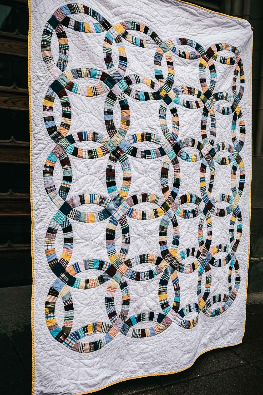 Double wedding ring memory quilt made with dress shirts and with white fabric as backing for them.