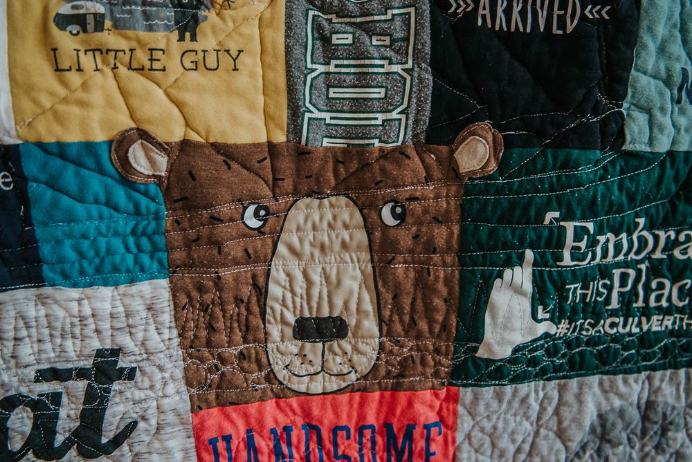 Patchwork memory quilt with a large square made from a pyjama shirt of a brown bear.