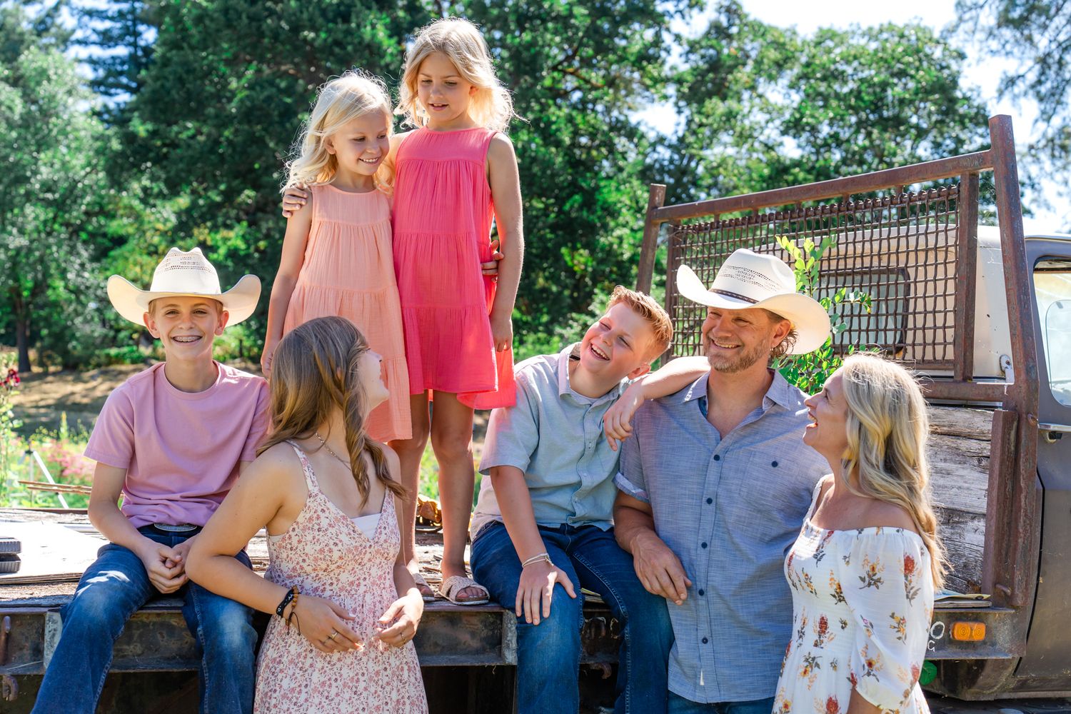 big family laughs together on the bed of a truck