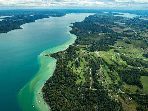 Aerial view of a coastline with turquoise waters and lush green landscape.