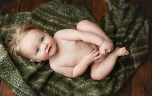 A 6-month-old lying on his back holding his feet. Greenville, SC newborn photographer, Easley, SC Newborn photographer