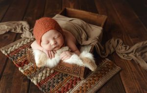 A newborn boy on fur with a organe bonnet. Greenville, SC newborn photographer, Easley, SC Newborn photographer