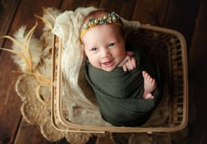 Newborn girl in a basket looking up smiling. Greenville, SC newborn photographer, Easley, SC Newborn photographer