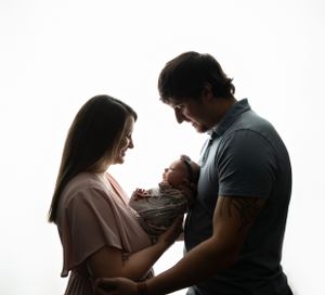 A backlit image of Mom and Dad with newborn baby. Greenville, SC newborn photographer, Easley, SC Newborn photographer