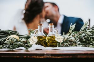 Focused on table details of a wedding while the couple kisses in the background in Sirimione, Italy.