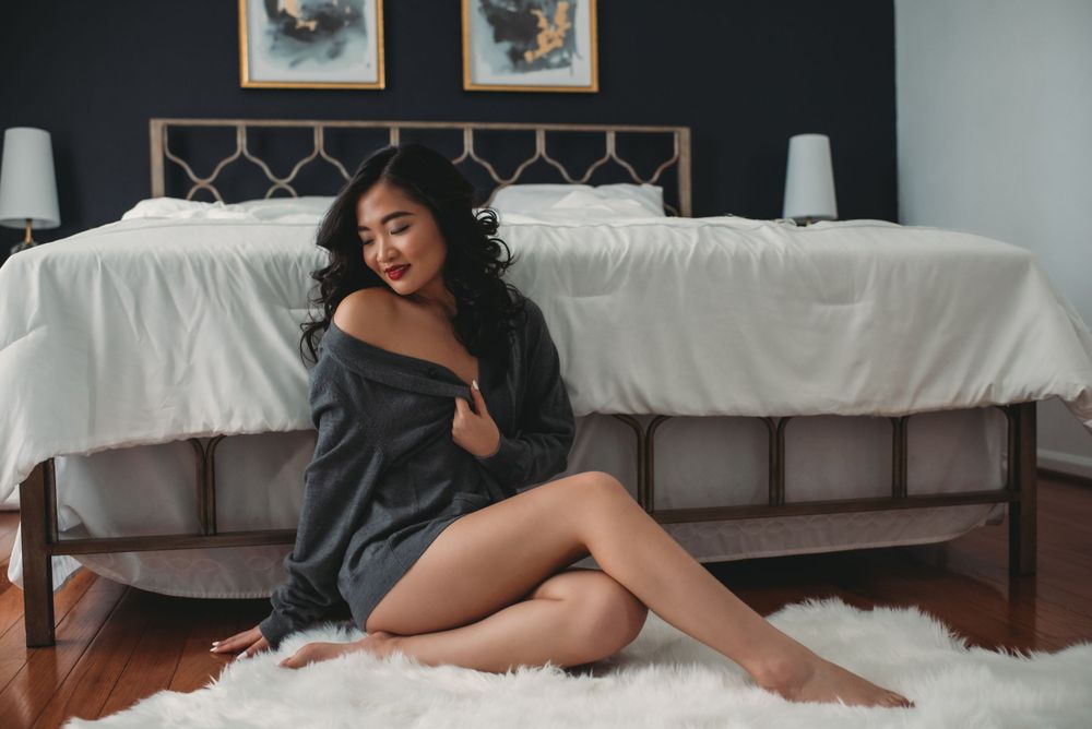 Asian woman in sweater during boudoir shoot