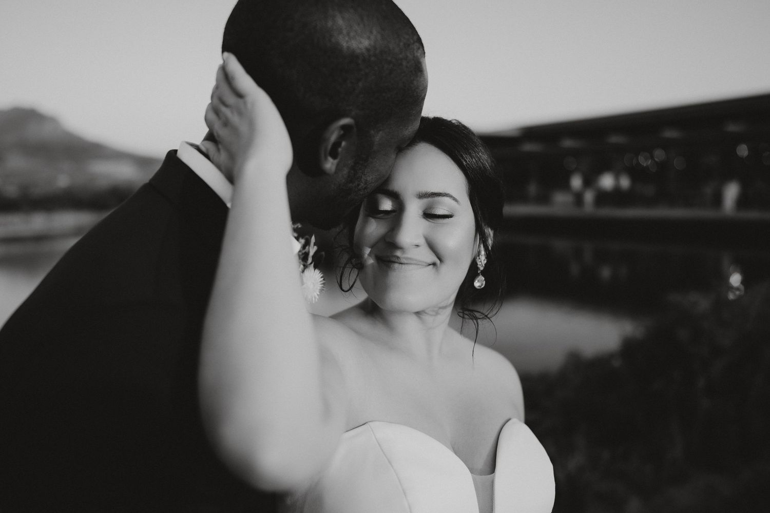Intimate black and white portrait of a couple sharing a tender moment outdoors.