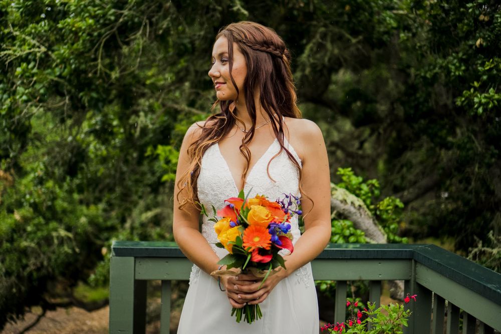 A bridal portrait featuring a white dress and vibrant orange and yellow bouquet.
