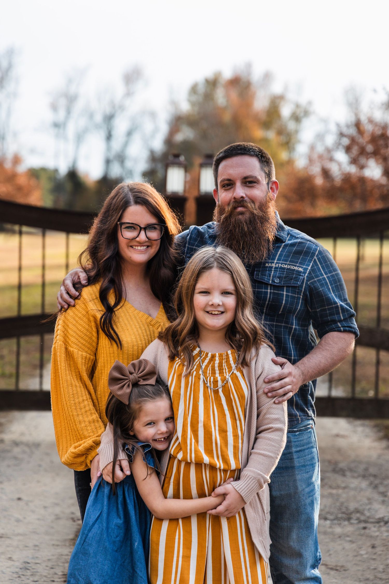 Family portrait in autumn featuring casual attire and natural outdoor setting.