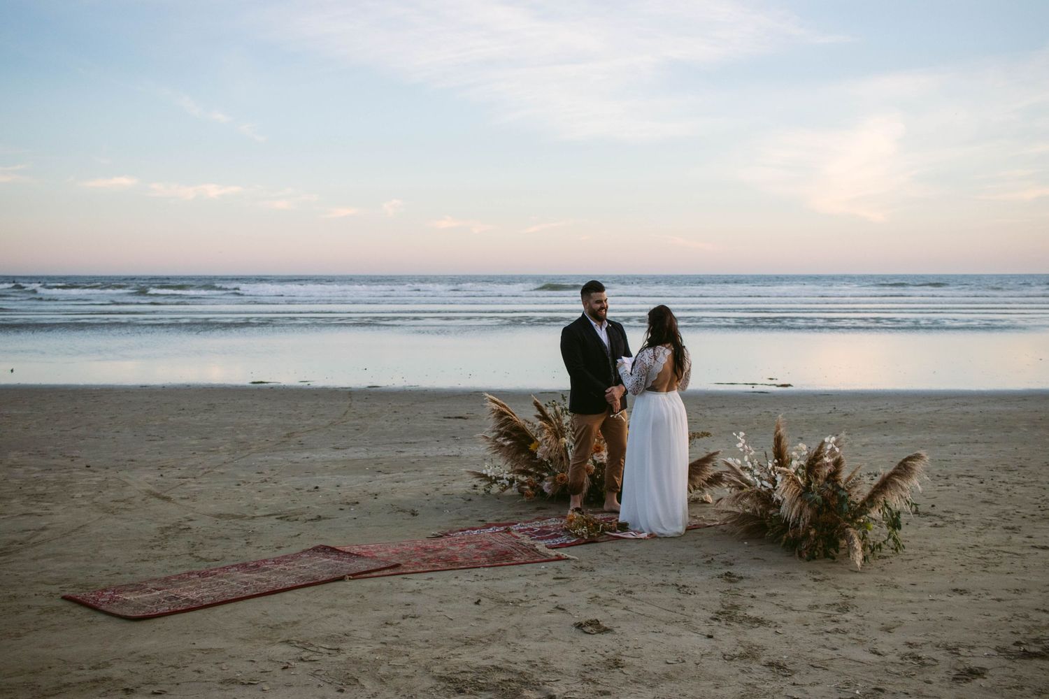 Groom smiling as bride reads her vows to him during their Tofino, British Columbia Beach Elopement