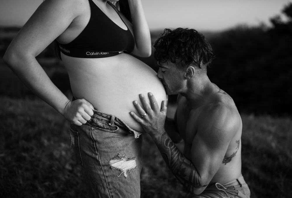 Close-up maternity photography showing tender moments between couple.