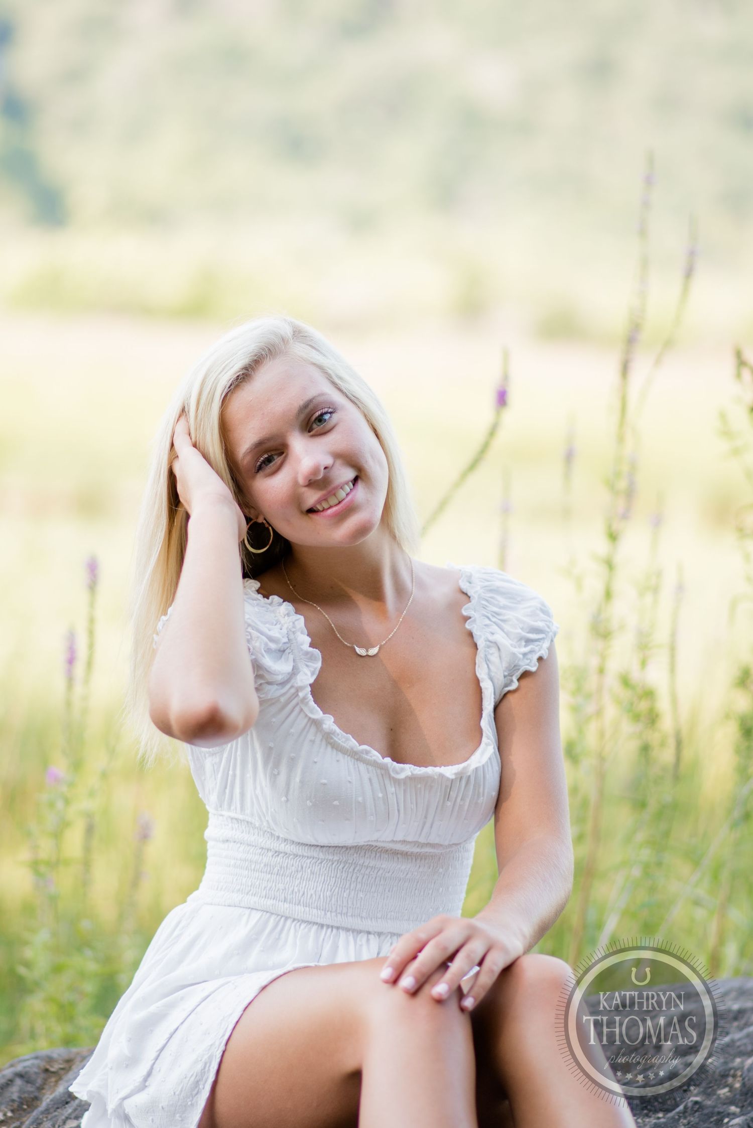 Natural outdoor portrait in a meadow with someone wearing a white ruffled dress.