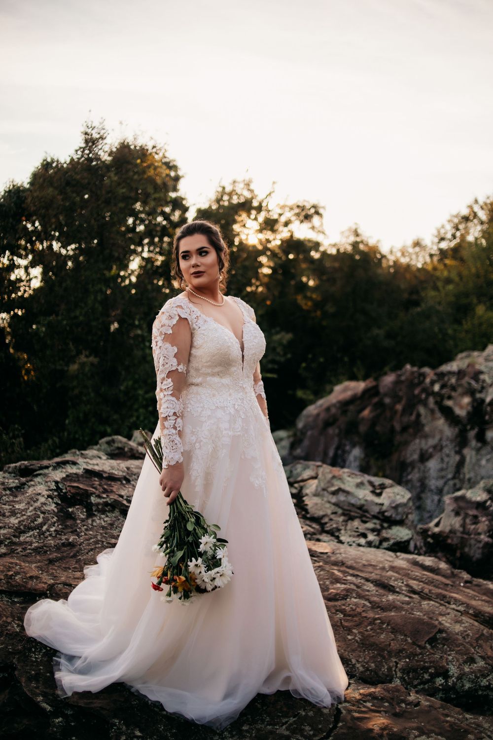 bride holding flowers on rocks