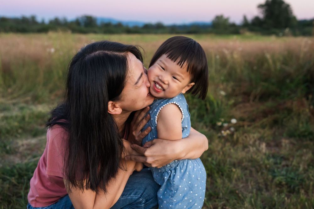 Mother snuggling and kissing her daughter during blue hour in Redmond.