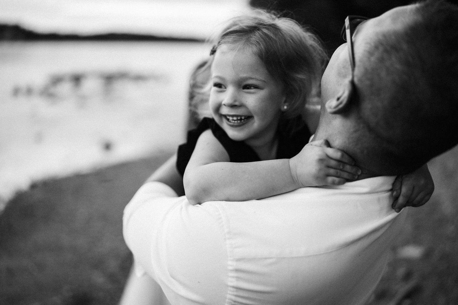 Black and white candid moment captured between parent and child outdoors.