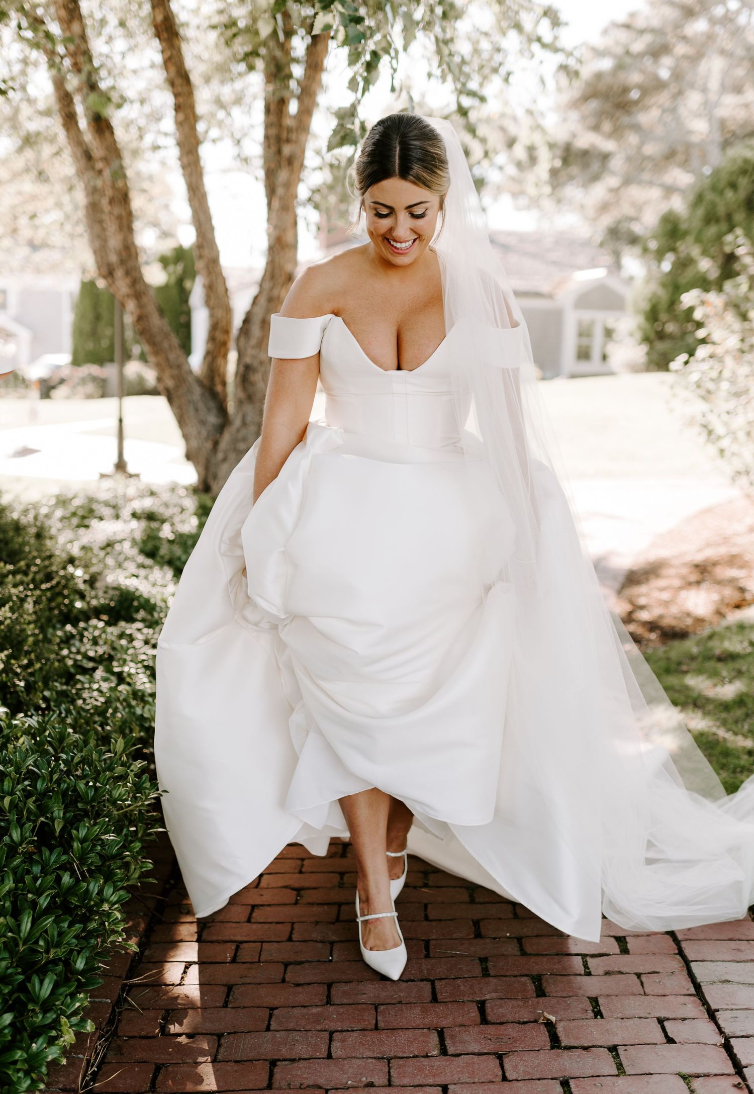 Close-up shots of a bride's white wedding dress and shoes on brick steps in an outdoor garden setting.