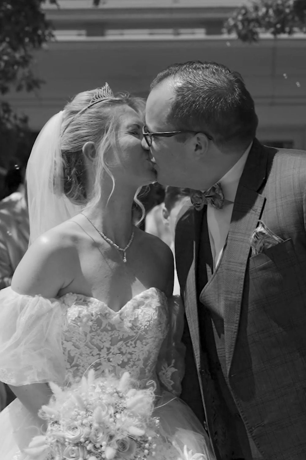 Black and white close-up sequence of a romantic wedding kiss.