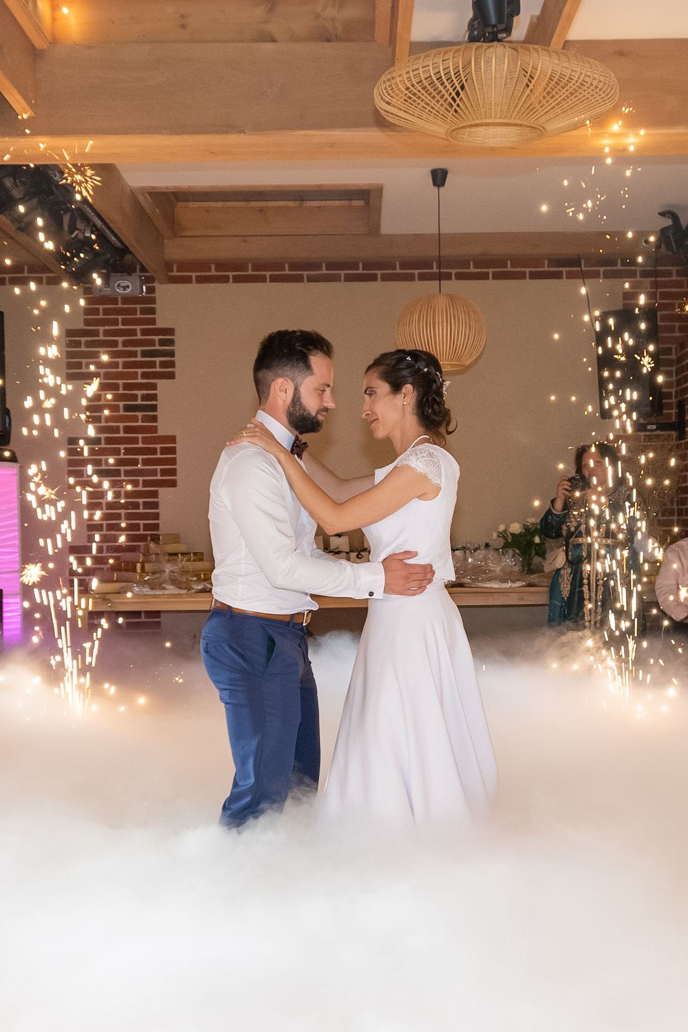 Newlyweds share their first dance surrounded by sparklers creating a magical effect on the dance floor.