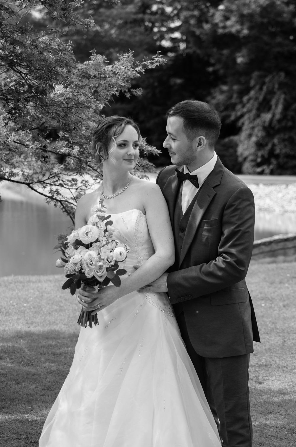 Romantic outdoor wedding portraits with bride holding white bouquet in a garden setting.