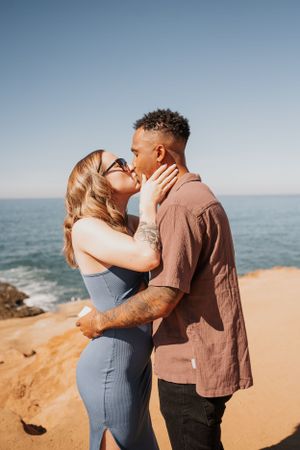 A loving embrace shared between a couple against a beautiful ocean backdrop.