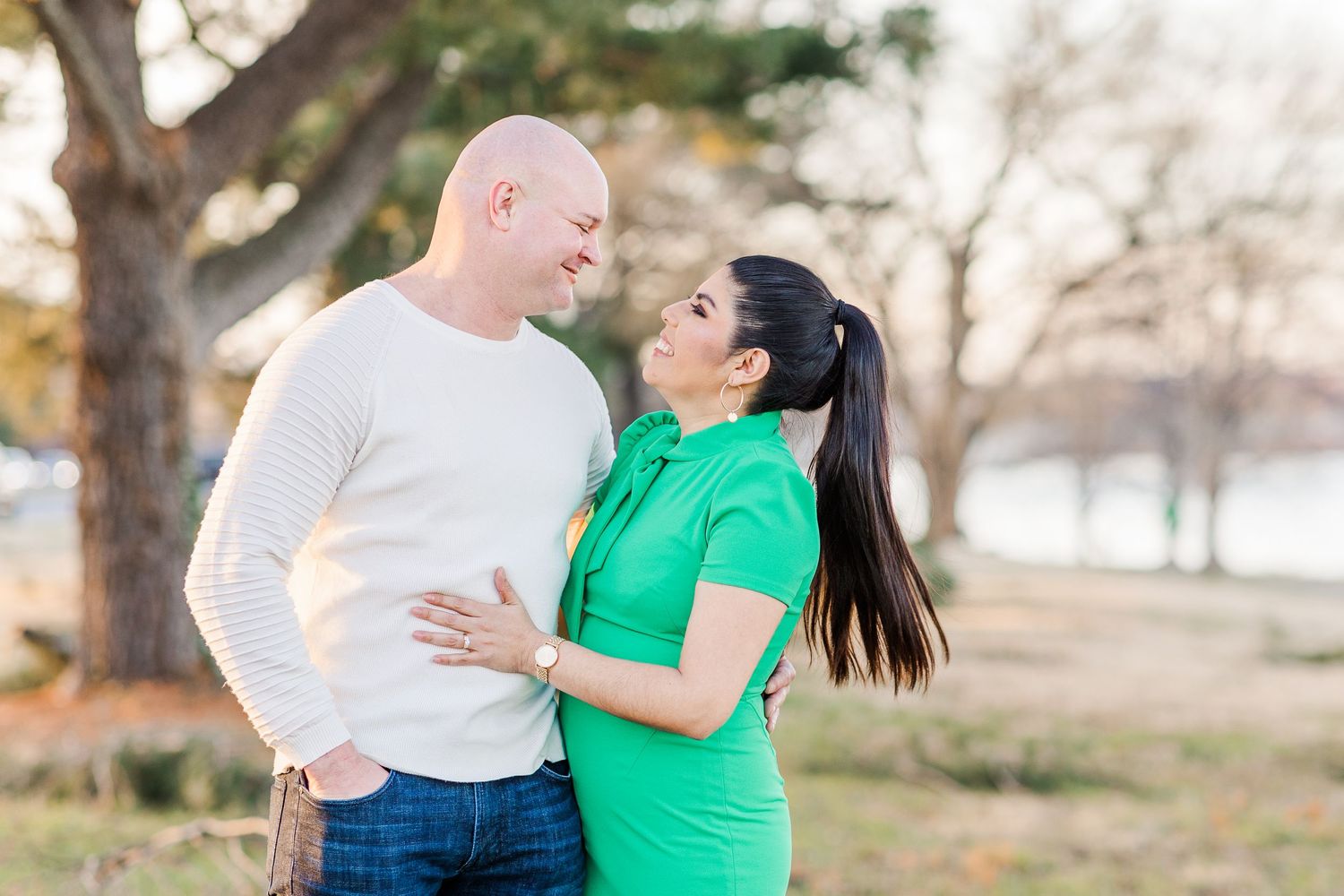 Couple embracing in outdoor setting during golden hour.