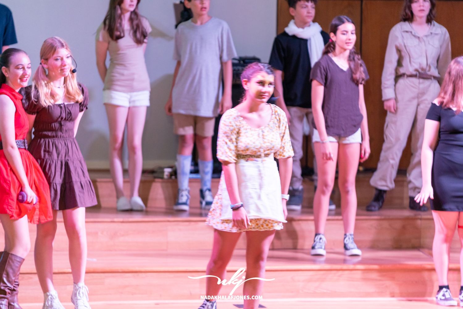 Theater performance with performers in casual attire on a wooden stage.