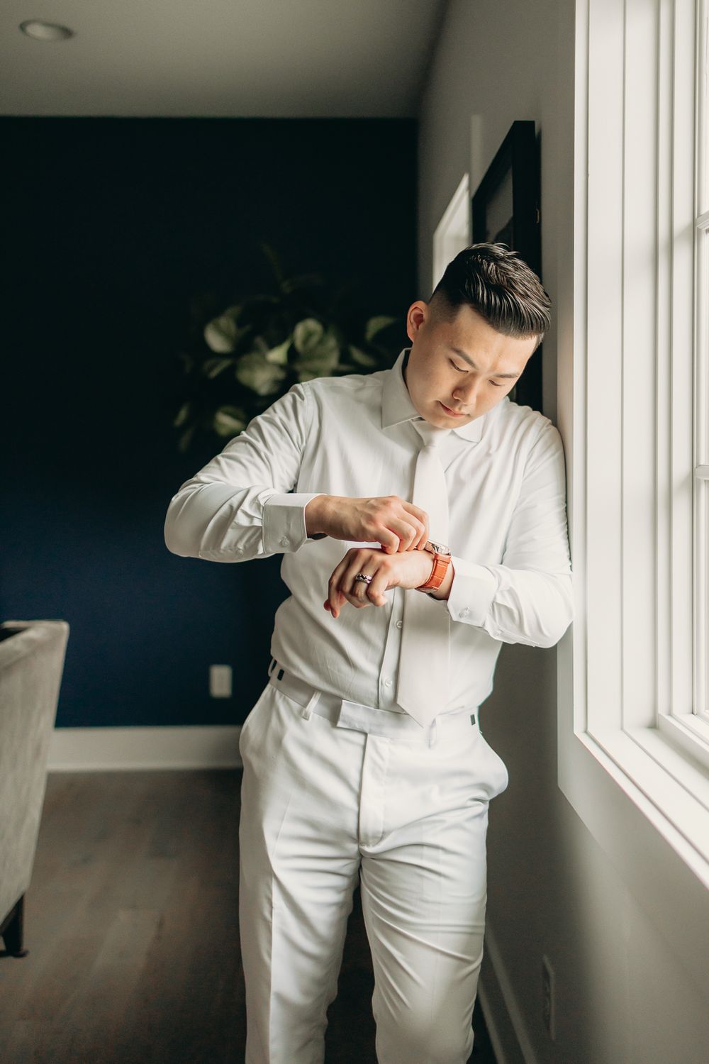 groom getting ready right next to the window