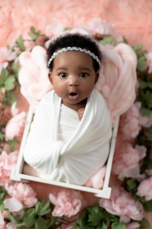 Newborn baby sleeping peacefully wrapped in a soft blanket during a studio session.