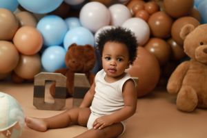 Milestone photoshoot featuring a child taking their first steps captured in a bright, cheerful studio.