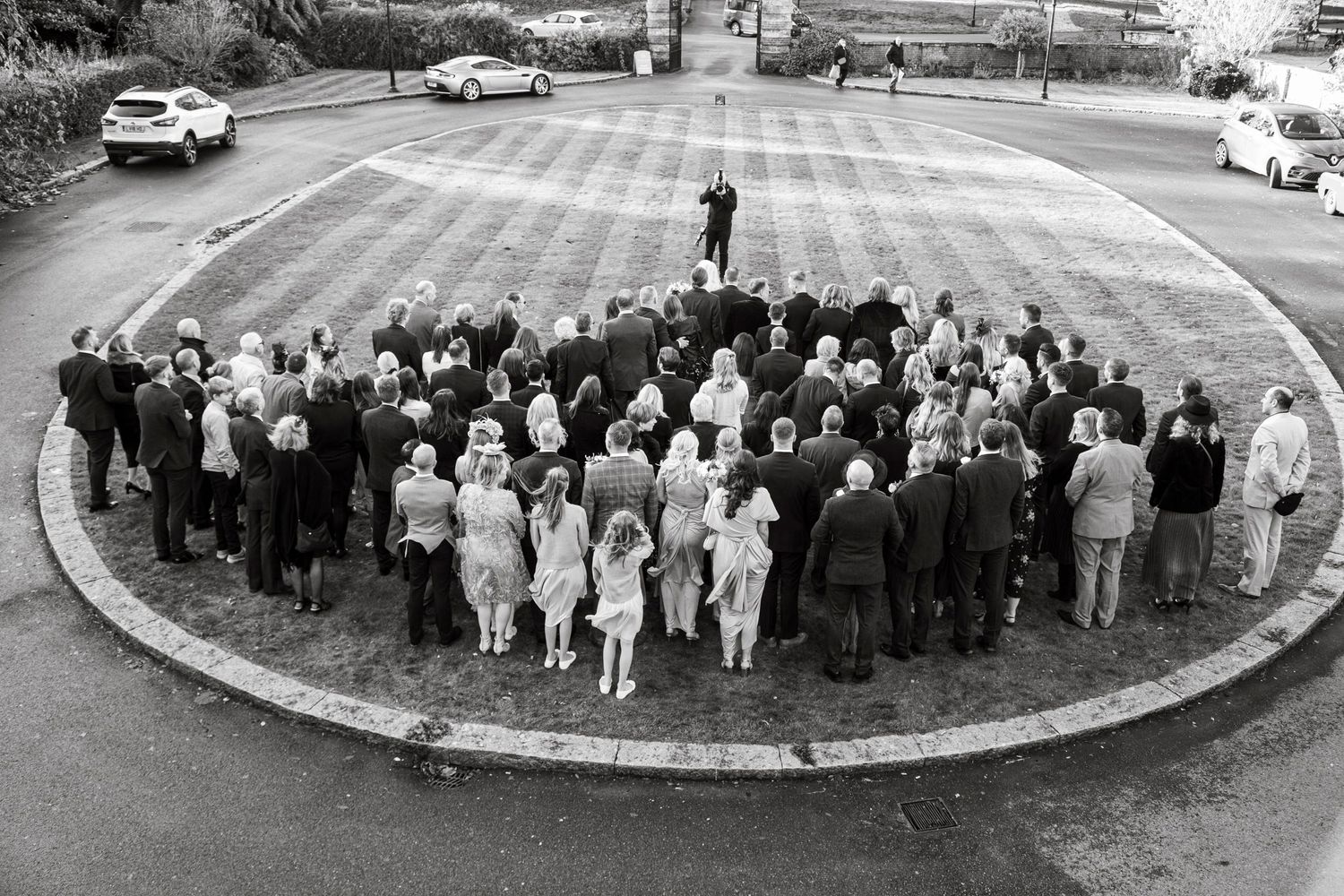 Aerial black and white shots of large wedding group formations on curved driveway.