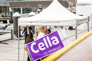Event setup with white tent and purple Cella banner on waterfront dock.