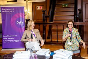 Business presentation setup with purple branded banner and speakers in traditional venue.
