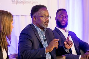 Professional panel speakers engage in discussion at corporate conference event.