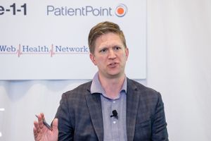 Speaker presenting at a PatientPoint healthcare conference with Web Health Network branding visible in background.